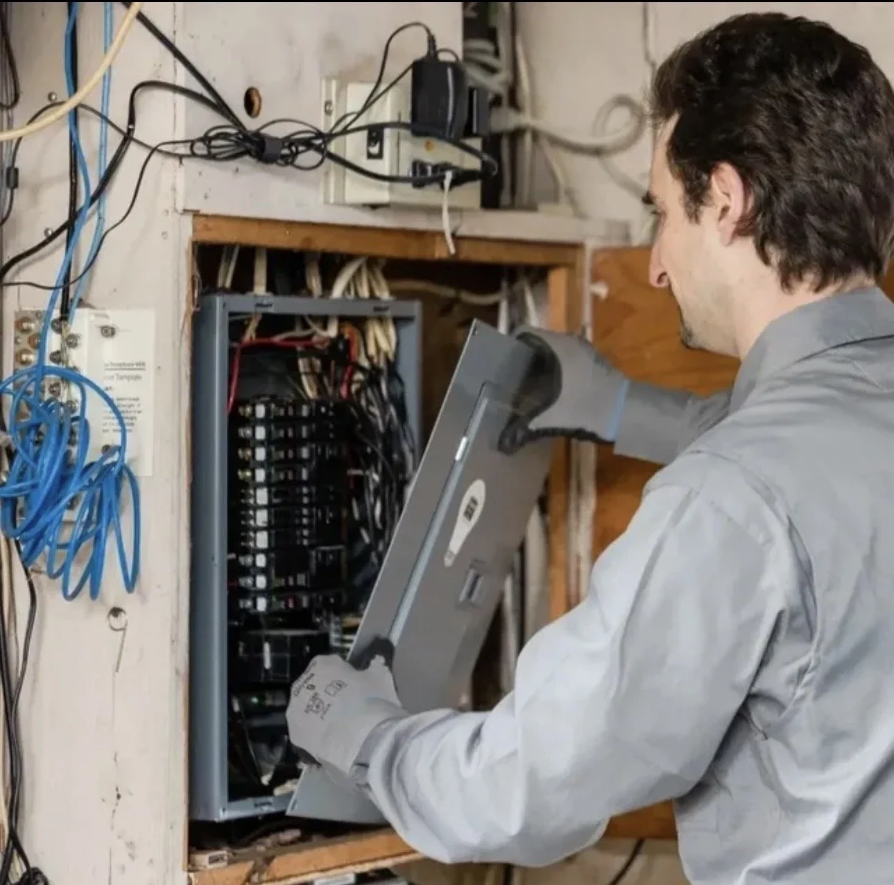 Mr. Speedy Electric technician testing an open electrical panel
